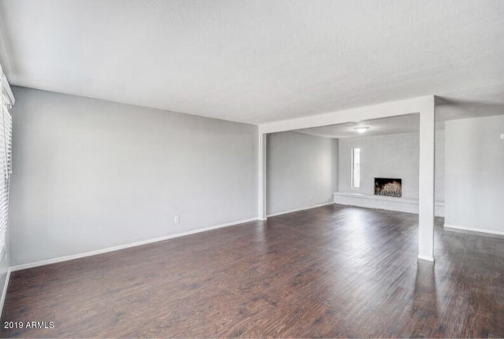 3249 West Citrus Way Phoenix, AZ 85017 - Photo 2 of 22 a view of empty room with wooden floor and fireplace