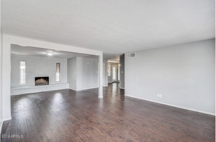 3249 West Citrus Way Phoenix, AZ 85017 - Photo 3 of 22 a view of an empty room with wooden floor and a fireplace