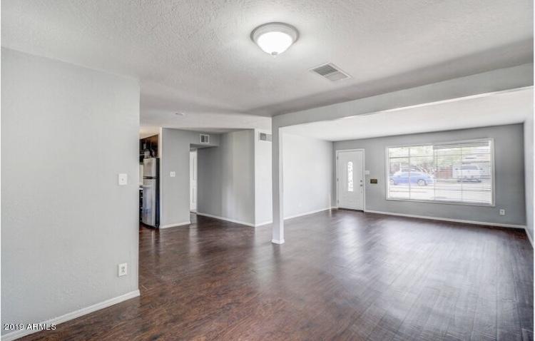 3249 West Citrus Way Phoenix, AZ 85017 - Photo 4 of 22 an empty room with wooden floor and windows