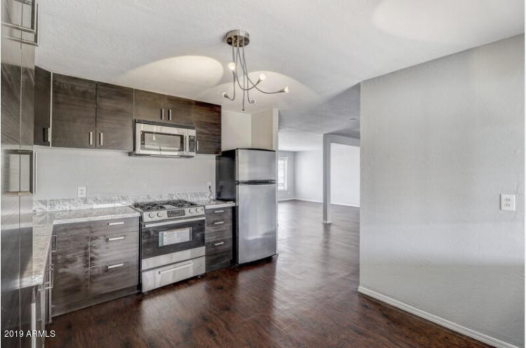 3249 West Citrus Way Phoenix, AZ 85017 - Photo 8 of 22 a kitchen with granite countertop a stove a sink and a refrigerator