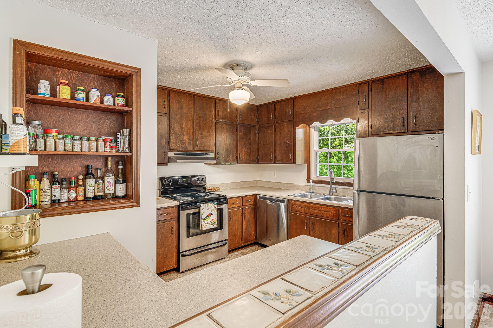 61 Spring Cove Drive Brevard, NC 28712 - Photo 12 of 39 a kitchen with stainless steel appliances granite countertop a refrigerator a sink dishwasher a stove a dining table and chairs with wooden floor