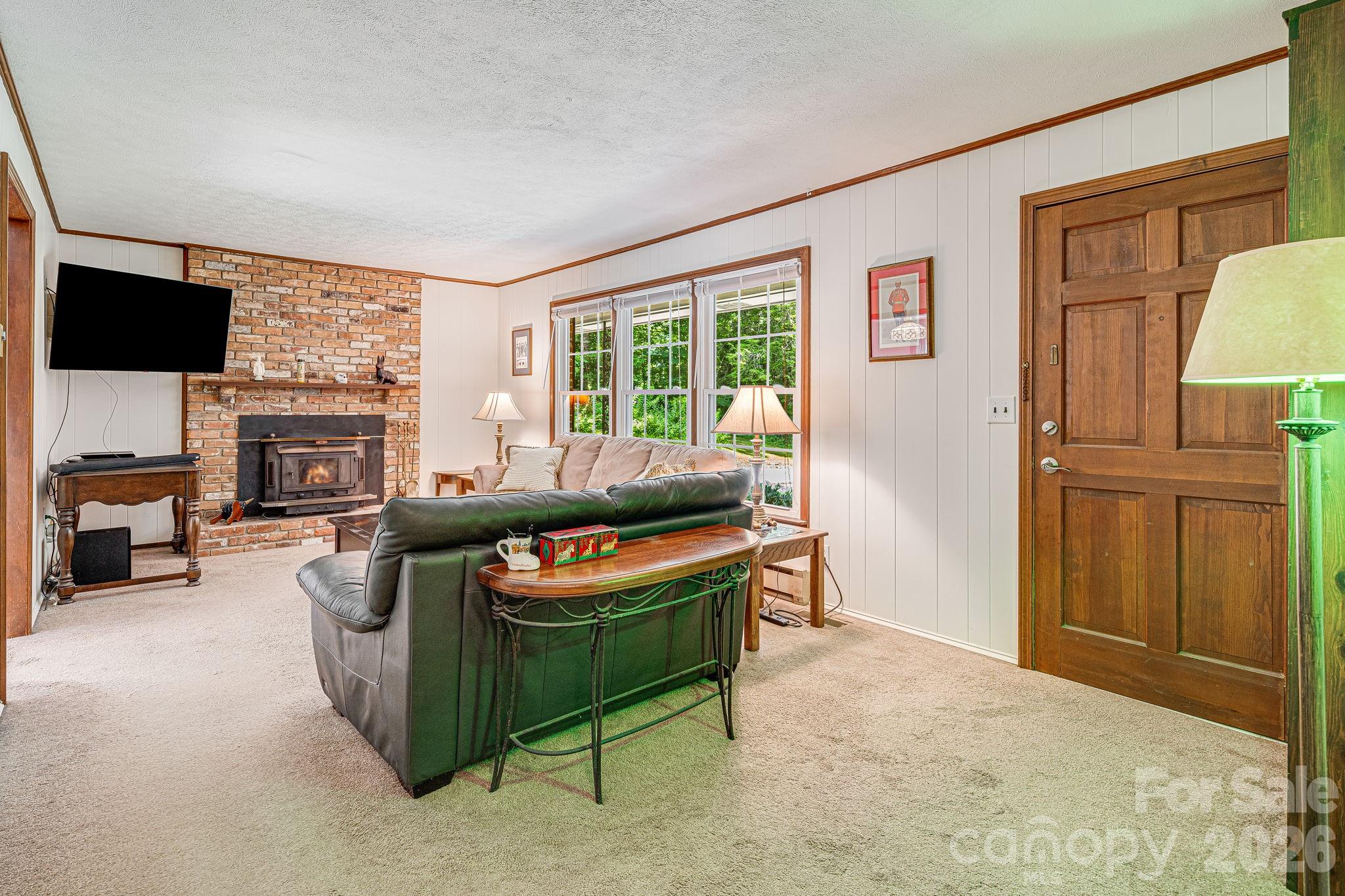 61 Spring Cove Drive Brevard, NC 28712 - Photo 6 of 39 a living room with furniture a flat screen tv and a fireplace