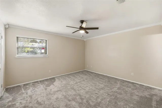 a view of a room with a ceiling fan and carpet