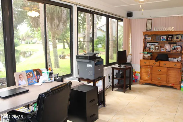 a view of a workspace with furniture and a window