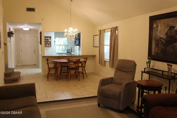 a dining room with furniture and a floor to ceiling window