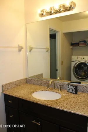 a bathroom with a granite countertop sink a mirror and vanity
