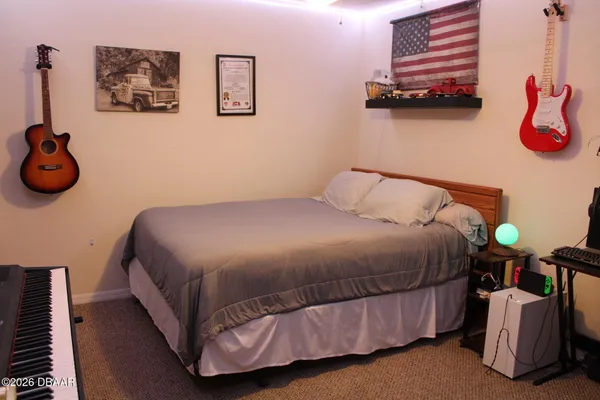 a bedroom with a bed and painting on the wall