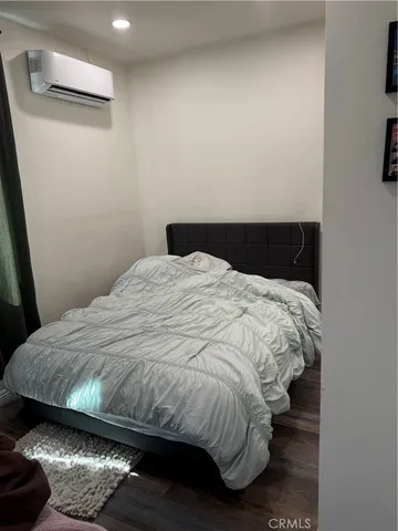 a bedroom with a bed and wooden floor