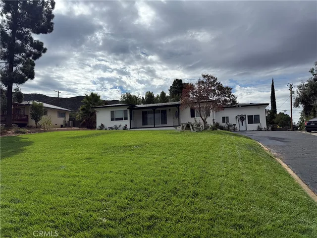 a view of house with yard and sitting area