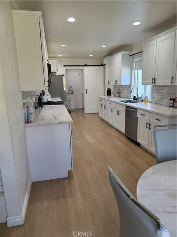 a kitchen with white cabinets and white appliances