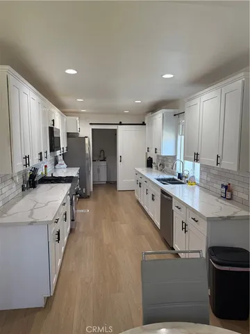 a large kitchen with stainless steel appliances lots of counter space and a sink