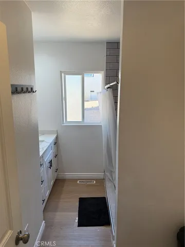 a bathroom with a sink a toilet a window and vanity