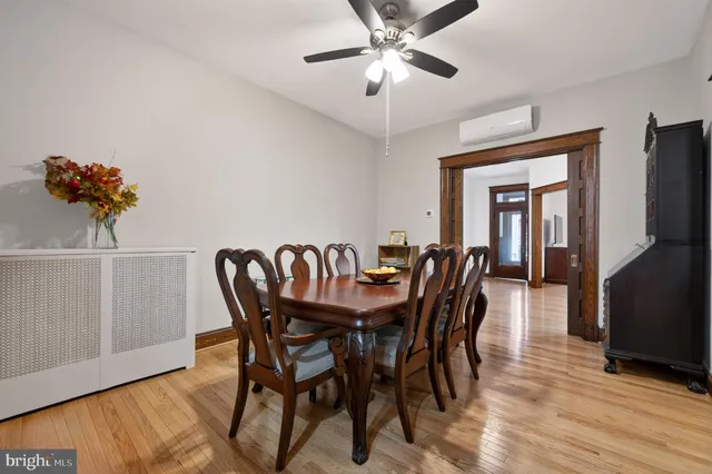 a kitchen with stainless steel appliances granite countertop a refrigerator a sink dishwasher a stove and a dining table with wooden floor