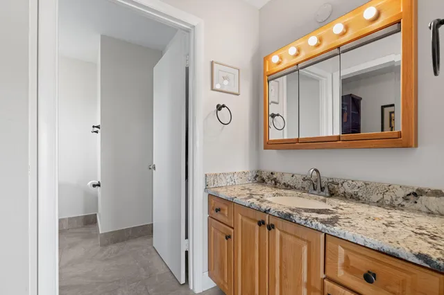 a bathroom with a granite countertop sink vanity and mirror
