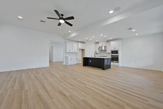 a kitchen with a sink cabinets and wooden floor
