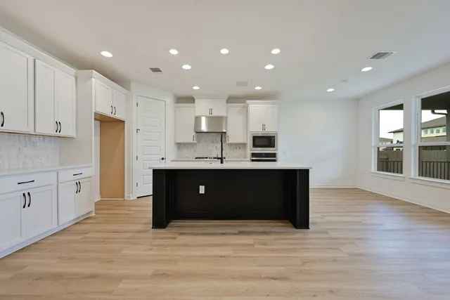 a kitchen with a sink a stove a microwave and cabinets