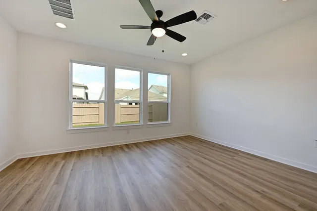 an empty room with closet and a ceiling fan