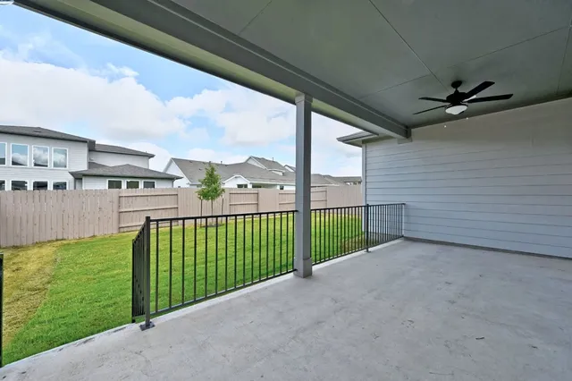 a view of a backyard with grass and wooden fence