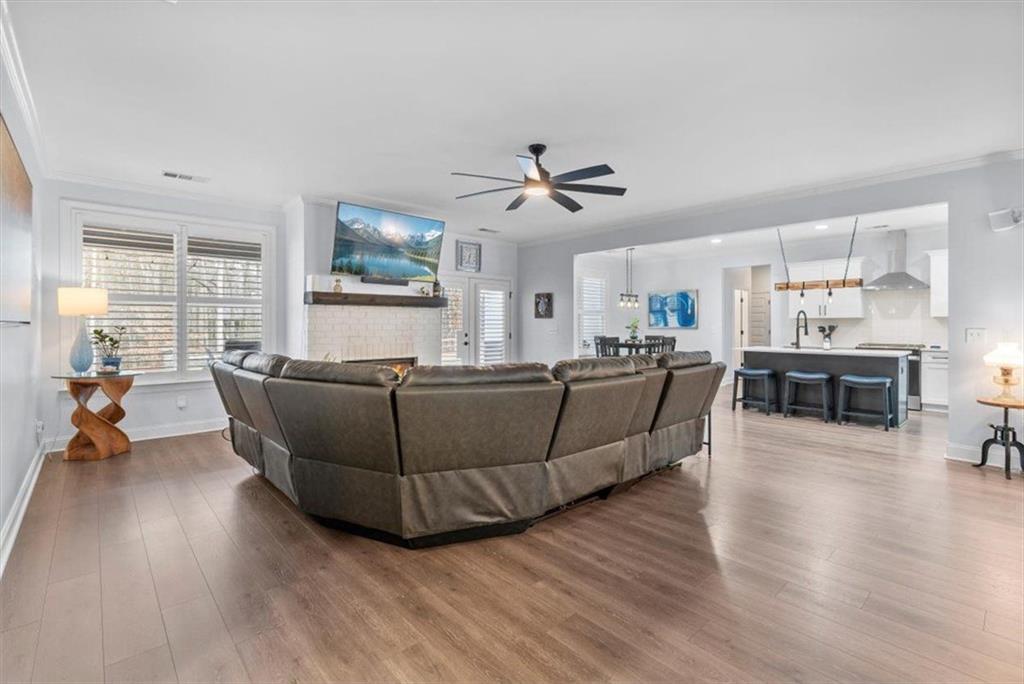 7705 Wandering Oak Way Cumming, GA 30041 - Photo 14 of 57 a living room with furniture wooden floor and a large window