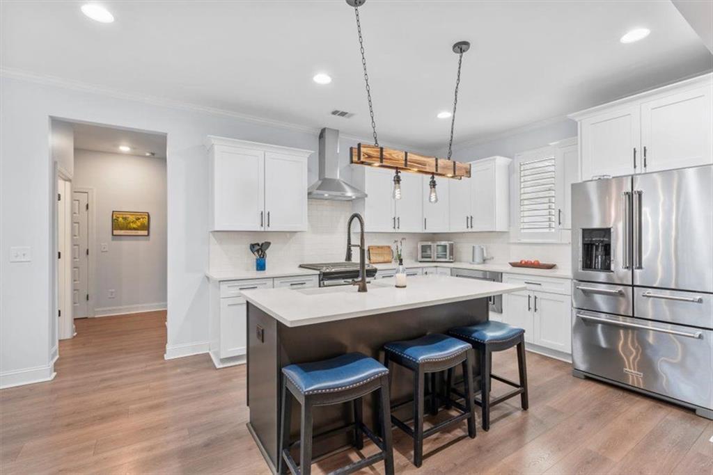 7705 Wandering Oak Way Cumming, GA 30041 - Photo 19 of 57 a kitchen with kitchen island a sink stove and refrigerator