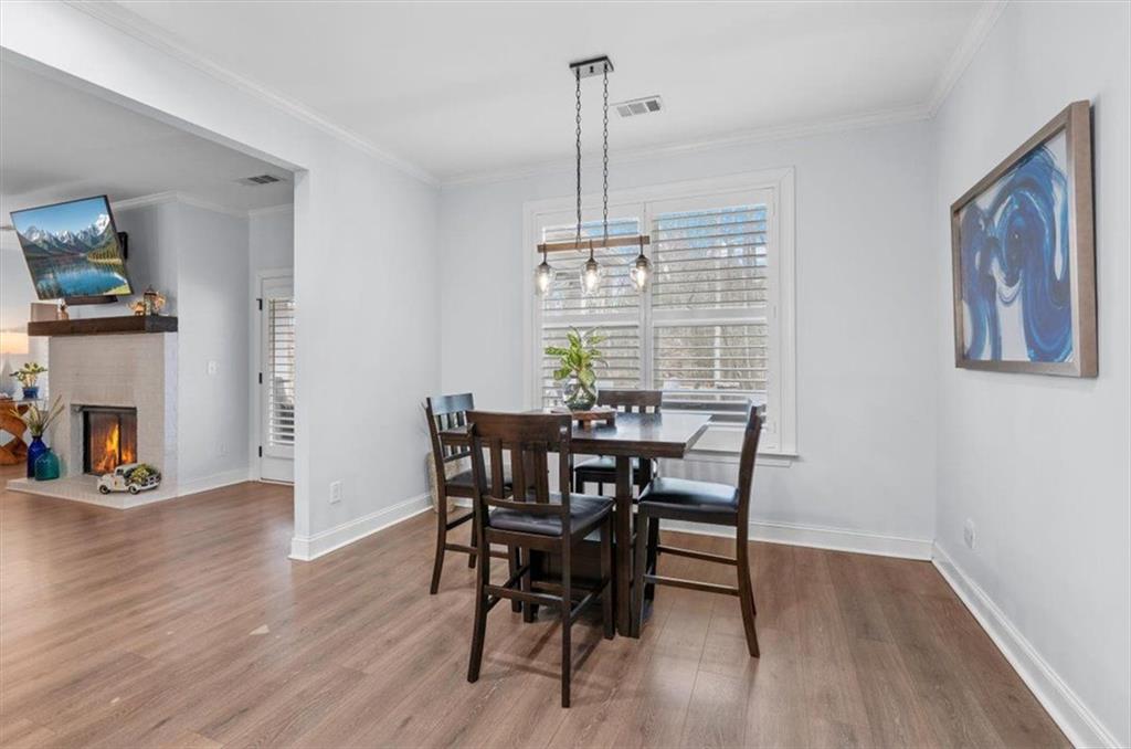 7705 Wandering Oak Way Cumming, GA 30041 - Photo 23 of 57 a view of a dining room with furniture window and wooden floor