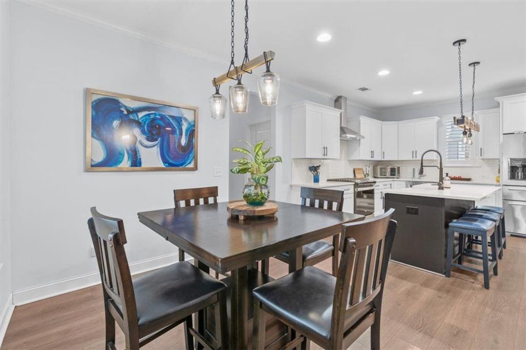 7705 Wandering Oak Way Cumming, GA 30041 - Photo 24 of 57 a view of a dining room with furniture a kitchen and kitchen chandelier