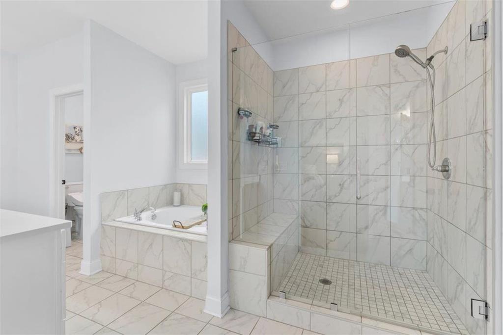 7705 Wandering Oak Way Cumming, GA 30041 - Photo 27 of 57 a bathroom with a bathtub sink and shower