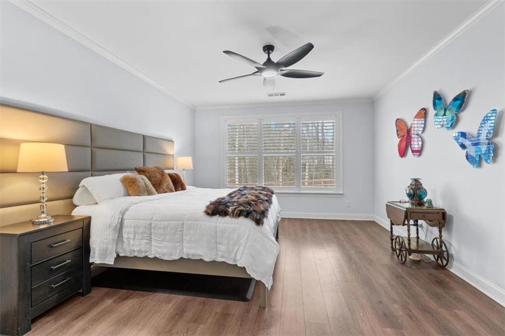 7705 Wandering Oak Way Cumming, GA 30041 - Photo 31 of 57 a bedroom with a bed and wooden floor