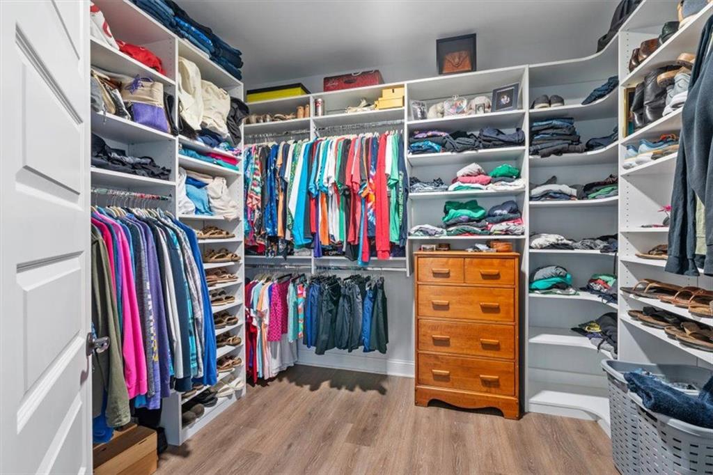 7705 Wandering Oak Way Cumming, GA 30041 - Photo 38 of 57 a view of walk in closet with clothes and shoes