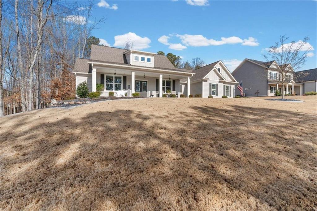 7705 Wandering Oak Way Cumming, GA 30041 - Photo 6 of 57 a front view of a house with a garden and balcony