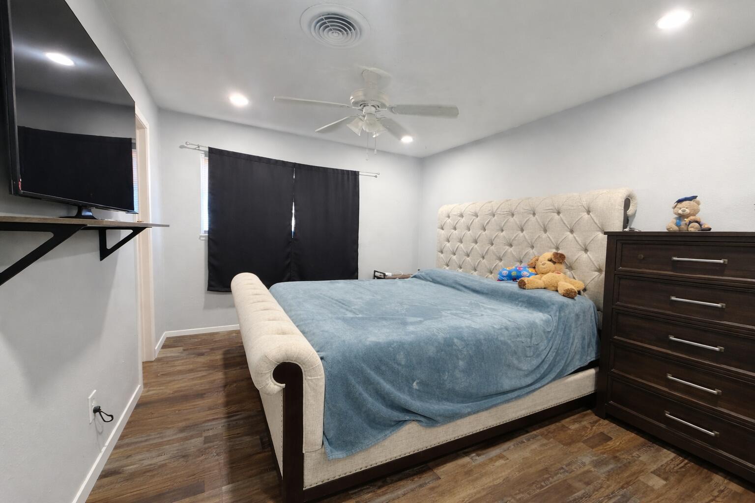 5308 48th Street Lubbock, TX 79414 - Photo 5 of 12 a bedroom with a bed and a flat tv screen on dresser