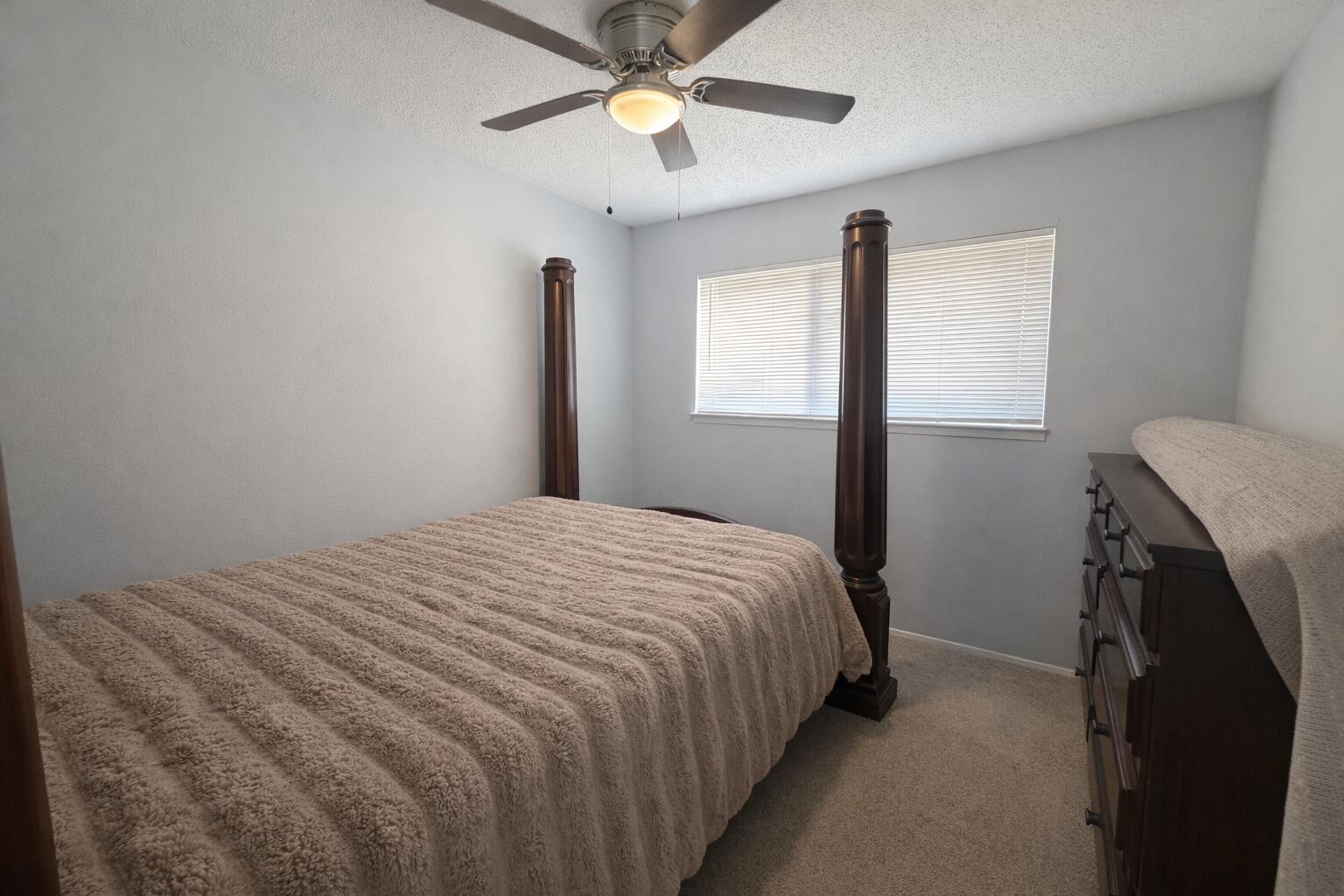 5308 48th Street Lubbock, TX 79414 - Photo 10 of 12 a bedroom with a bed and a chandelier