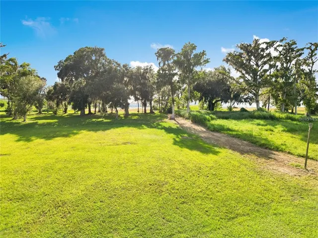 an aerial view of a residential houses with outdoor space and river view