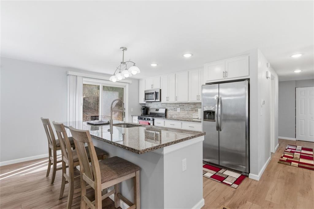 3106 Greenfield Road Glenshaw, PA 15116 - Photo 12 of 47 a kitchen with stainless steel appliances granite countertop a dining table chairs refrigerator and microwave