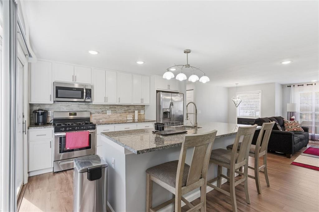3106 Greenfield Road Glenshaw, PA 15116 - Photo 13 of 47 a kitchen with stainless steel appliances granite countertop a stove top oven a sink dishwasher and a dining table with wooden floor