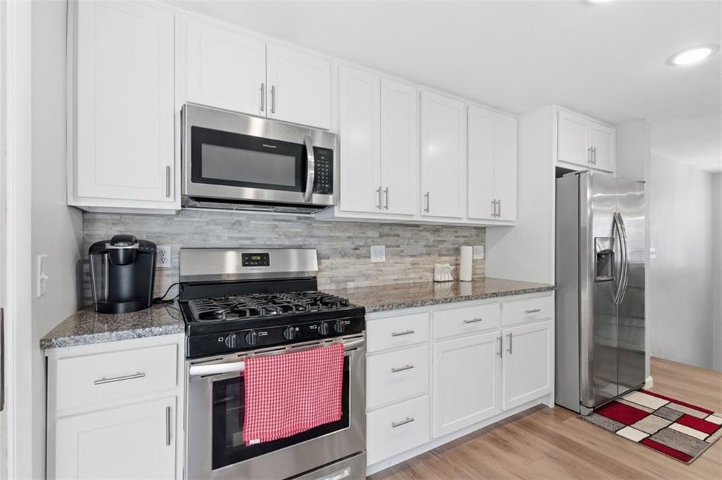 3106 Greenfield Road Glenshaw, PA 15116 - Photo 17 of 47 a kitchen with stainless steel appliances granite countertop a stove a microwave and a refrigerator
