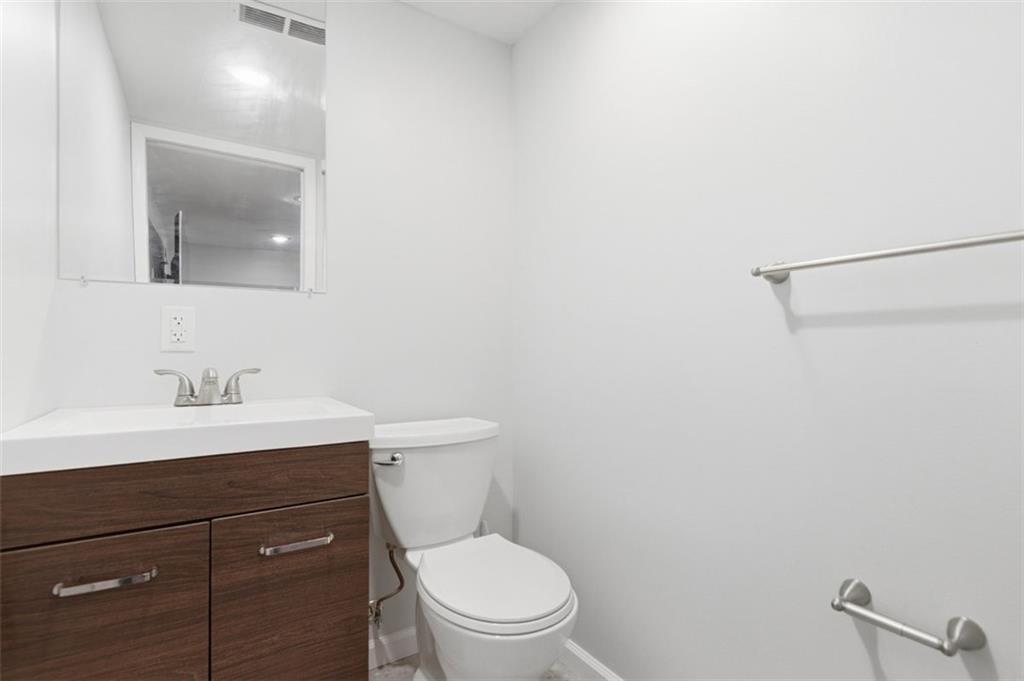 3106 Greenfield Road Glenshaw, PA 15116 - Photo 38 of 47 a bathroom with a toilet a sink a mirror and vanity