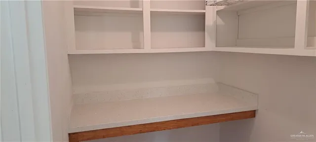 a view of an empty room with wooden floor and a cabinet