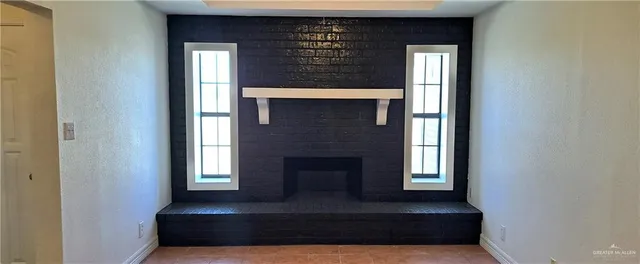 a living room with a fireplace and windows
