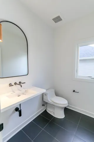 a bathroom with a toilet sink and mirror