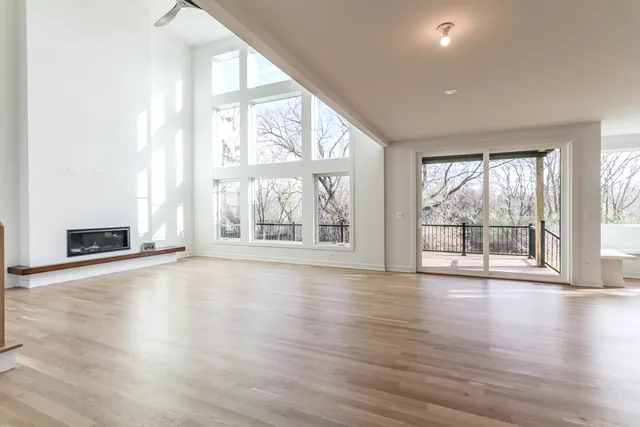 an empty room with wooden floor and fireplace