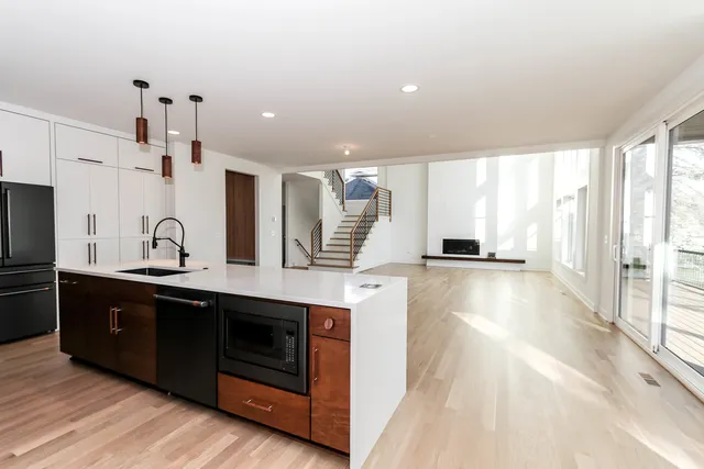 a large kitchen with stainless steel appliances a large counter top a stove and a refrigerator