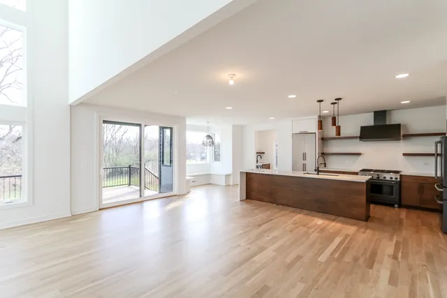a large kitchen with stainless steel appliances kitchen island granite countertop a large counter top and wooden floors