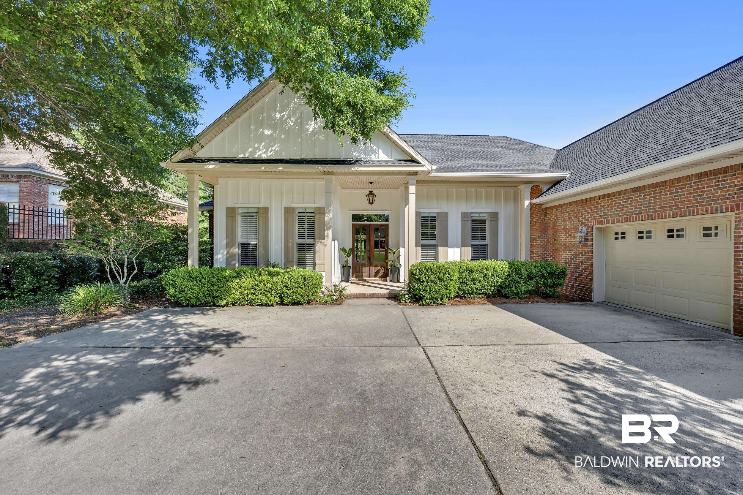 8137 Pine Run Daphne, AL 36527 - Photo 3 of 67 Exterior featuring board and batten siding, brick accents, a gabled entry, concrete driveway, and an attached garage with panel-style door