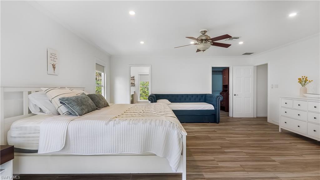 2920 24th Avenue Southeast Naples, FL 34117 - Photo 21 of 50 a bedroom with a bed and a chandelier
