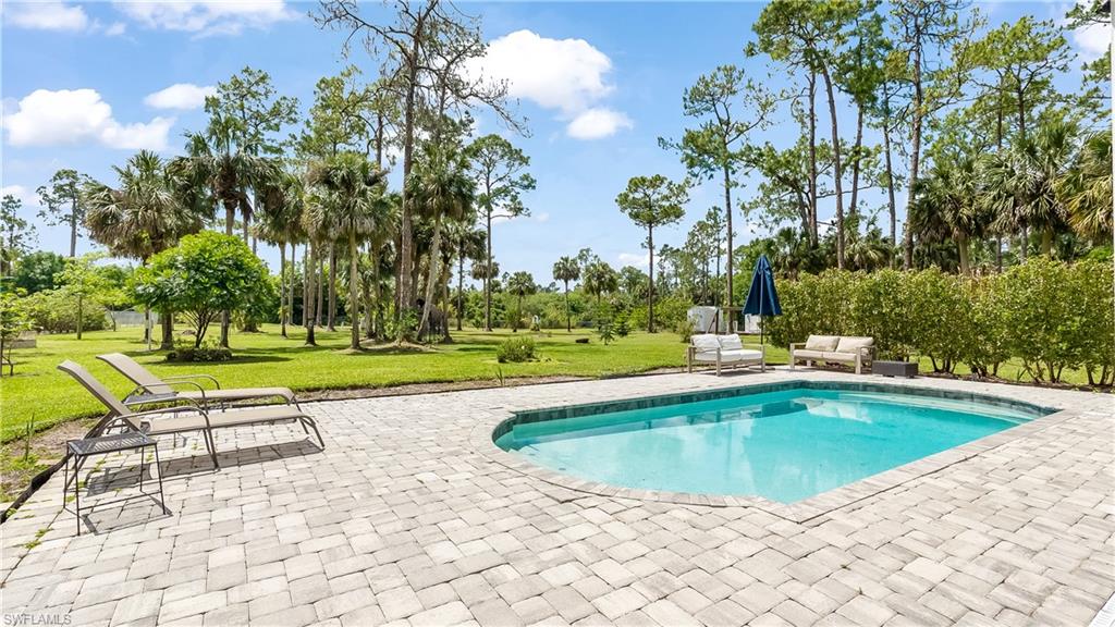 2920 24th Avenue Southeast Naples, FL 34117 - Photo 28 of 50 a view of swimming pool with outdoor seating and yard