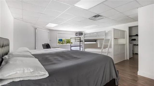 a spacious bedroom with a bed and a flat screen tv