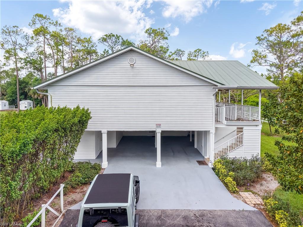 2920 24th Avenue Southeast Naples, FL 34117 - Photo 6 of 50 a view of a house with a yard plants and large tree