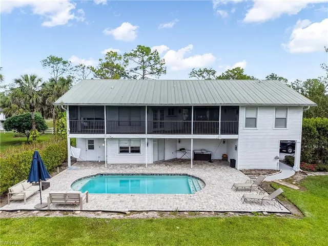 a view of a house with a yard balcony and sitting area