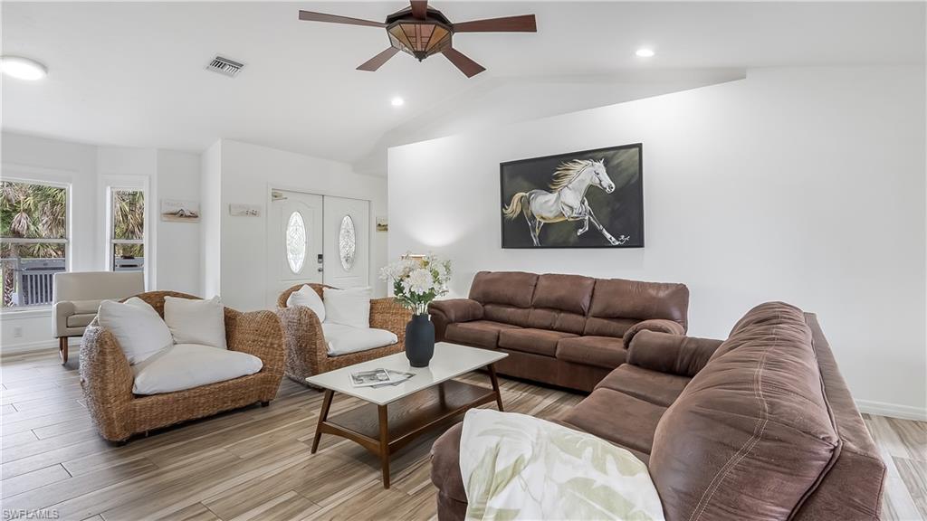 2920 24th Avenue Southeast Naples, FL 34117 - Photo 10 of 50 a living room with furniture and a wooden floor